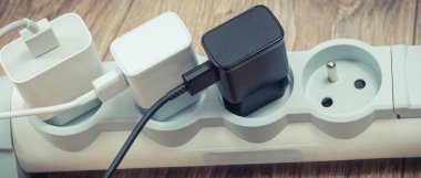 Akıllı telefon, elektrik kablosuna bağlı cep telefonu şarjı. Çeşitli aygıtlar şarj etme kavramı