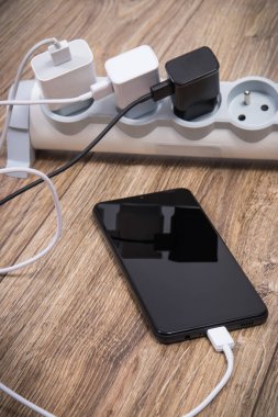 Akıllı telefon, cep telefonu ve elektrik hattına bağlı şarj cihazları. Çeşitli aygıtlar şarj etme kavramı