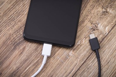 Şarj kablosu olan akıllı telefon. Cep telefonu şarj kavramı