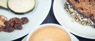 Beyaz tabakta taze pişmiş kabak hamuru ve bir fincan beyaz kahve. Tatlı nefis.