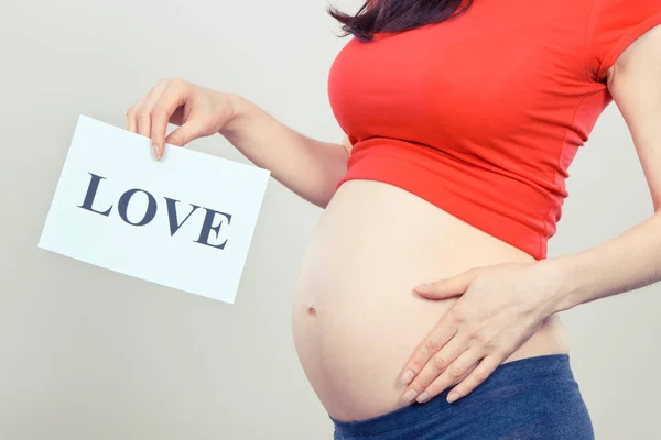 Gravid Kvinna Med Vitt Kort Med Inskription Kärlek Förväntar Nyfödda — Stockfoto