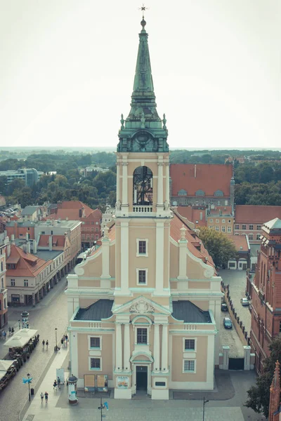 stock image Torun, Poland - August 19, 2022: View from tower on church of Holy Spirit and other old or modern buildings in center of polish city Torun. Vintage photo