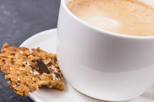一杯咖啡加牛奶和新鲜的自制燕麦饼干加蜂蜜和不同的健康种子 美味的脆甜食 — 图库照片