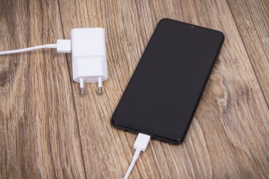 Akıllı telefon, cep telefonu ve şarj aleti boş aküyü şarj etmek için kullanılıyor. Çeşitli aygıtlar şarj etme kavramı