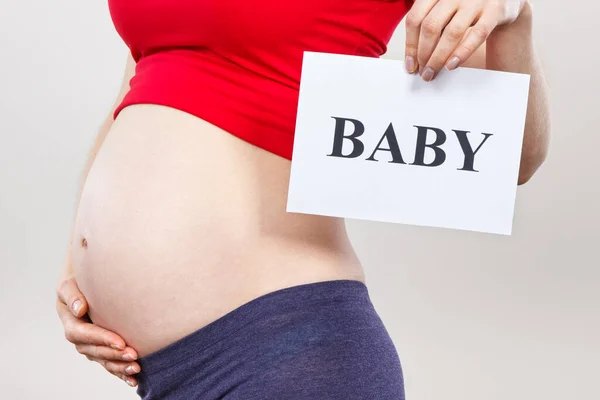 Kvinna Gravid Håller Vitt Kort Med Inskription Baby Förväntar Nyfödda — Stockfoto