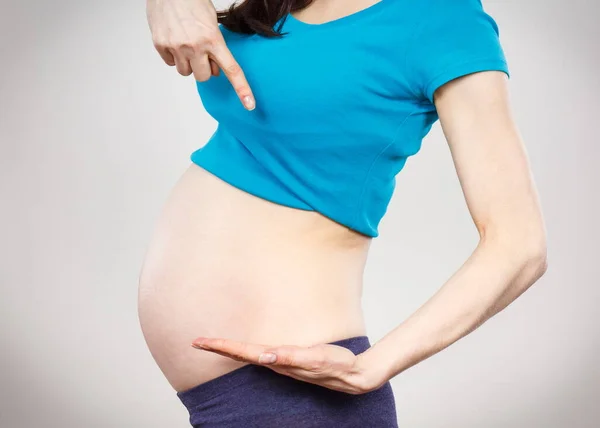 Γυναίκα Εγκυμοσύνη Δείχνει Άδειο Χέρι Για Κείμενο Διαφορετικά Προϊόντα Περιμένω — Φωτογραφία Αρχείου
