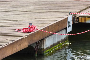 Yat çapasının bir parçası olarak ahşap köprüde renkli bir ip. Yelkenlinin ayrıntıları. Ulaşım