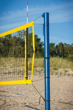 Kumsaldaki kumda voleybol sarı ağı. Spor, eğlence ve temiz havada sağlıklı yaşam tarzları. Tatil zamanı.
