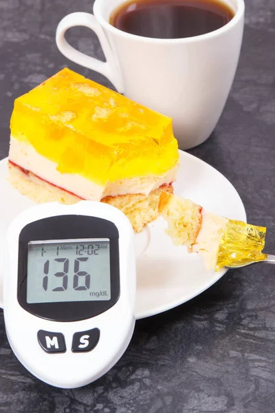 Glucose meter for checking and measuring sugar level, creamy sweet sponge cake with jelly and cup of coffee. Nutrition during diabetes. Festive dessert