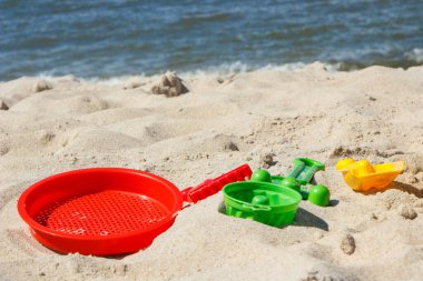 Çocuklar dinlenmek ya da kumsalda oynamak için plastik oyuncaklar. Yaz, tatil ve çocuk gelişimi