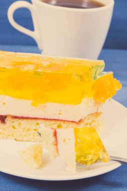 Ev yapımı kremalı meyveli kek, jöle ve bir fincan sade kahve. Farklı durumlar için lezzetli bir tatlı.