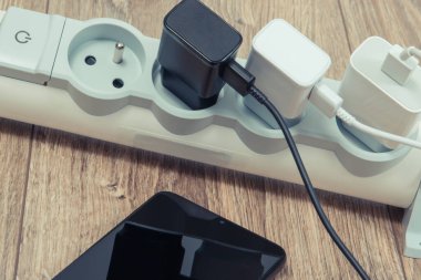 Akıllı telefon, cep telefonu ve elektrik hattına bağlı şarj cihazları. Çeşitli aygıtlar şarj etme kavramı