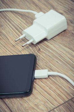Akıllı telefon, cep telefonu ve şarj aleti boş aküyü şarj etmek için kullanılıyor. Çeşitli aygıtlar şarj etme kavramı