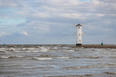 Swinoujscie, Batı Pomeranian - Polonya - 13 Haziran 2021: Yel değirmeni Stawa Mlyny 'ye karakteristik yön bulma işareti olarak bakın. Denizde fırtınalı ve rüzgarlı bir gün