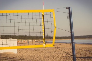 Kumsaldaki kumda voleybol sarı ağı. Spor, eğlence ve temiz havada sağlıklı yaşam tarzları. Tatil zamanı.