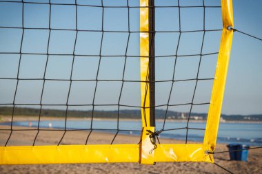 Kumsaldaki kumda voleybol sarı ağı. Spor, eğlence ve temiz havada sağlıklı yaşam tarzları. Tatil zamanı.