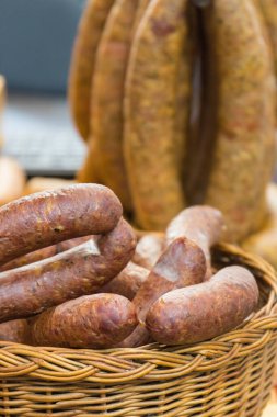 Bir yığın taze tütsülenmiş sosis ve sepetteki baharatlar.