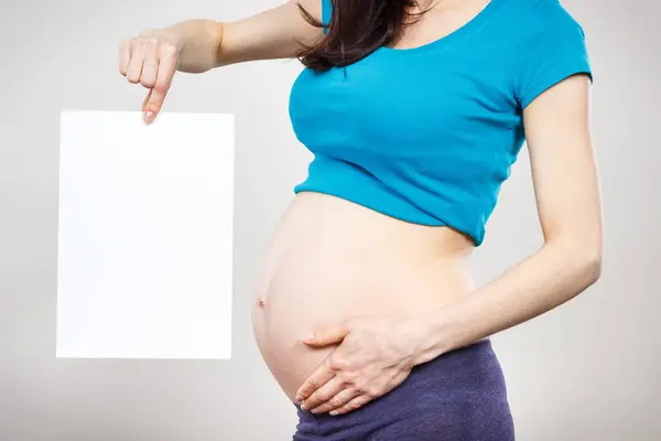 Žena Těhotenství Drží Prázdnou Bílou Kartu Pro Text Čekám Novorozence — Stock fotografie