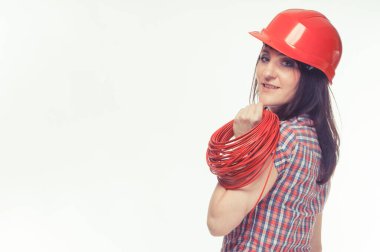 Kırmızı başlıklı, gülen kadın mühendis ve kırmızı elektrik kablosu. Teknoloji ve mühendislik. Yazı veya metin için yer