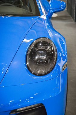 Poznan, Polonya - 08 Nisan 2022: Poznan Motor Fuarı. Mavi Porsche 911 'in ön lambasına bakın. Ayrıntı ve aracın parçası