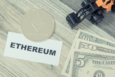 Ethereum madeni para, minyatür kazıcı ve dolar banknotları. Kripto para biriminin sembolü. Uluslararası ağ ödemesi. Finans kavramı