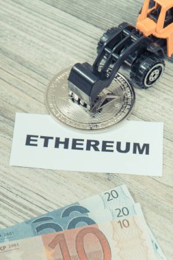 Ethereum, minyatür kazıcı ve euro. Kripto para biriminin sembolü. Uluslararası ağ ödemesi. Finans kavramı