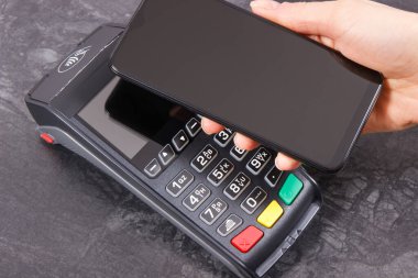 Cep telefonu ya da ödeme terminali olan akıllı telefon. Kredi kartı okuyucu. Alışveriş için para ödemeden. Finans ve bankacılık kavramı