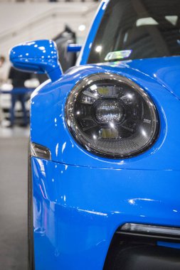 Poznan, Polonya - 08 Nisan 2022: Poznan Motor Fuarı. Mavi Porsche 911 'in ön lambasına bakın. Ayrıntı ve aracın parçası