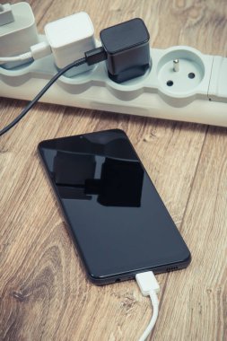 Akıllı telefon, cep telefonu ve elektrik hattına bağlı şarj cihazları. Çeşitli aygıtlar şarj etme kavramı