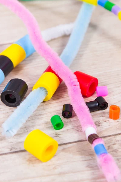 Thread, creative sticks and colorful beads used to making bracelets, learn counting and arranging various shapes. Development of kids motor skills, creativity, coordination and logical thinking