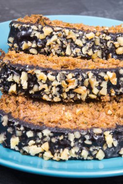 Pieces of zucchini dough with nuts and raisins on blue glass plate. Delicious dessert