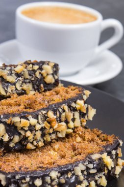 Siyah tabakta taze pişmiş kabak hamuru ve bir fincan beyaz kahve. Tatlı nefis.