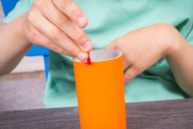 Anaokulunun elleri plastik toka ve karton rulo ile oynuyor. Çocukların motor becerilerinin, koordinasyonun, yaratıcılığın ve mantıksal düşüncenin geliştirilmesi