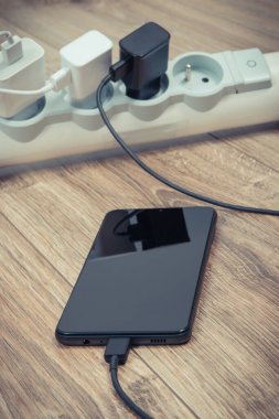 Akıllı telefon, cep telefonu ve elektrik hattına bağlı şarj cihazları. Çeşitli aygıtlar şarj ediliyor