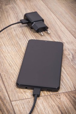 Akıllı telefon, cep telefonu ve şarj aleti boş aküyü şarj etmek için kullanılıyor. Çeşitli aygıtlar şarj etme kavramı