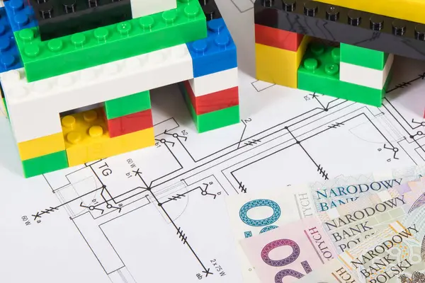Small houses made of colorful toy blocks, housing plan with electric installation and polish currency money. Subject of building or renting home