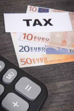 Hesap makinesi, yazıt vergisi, euro banknotları. Bir önceki yılın vergi hesapları ve ödemeleri. Ahşap arkaplan