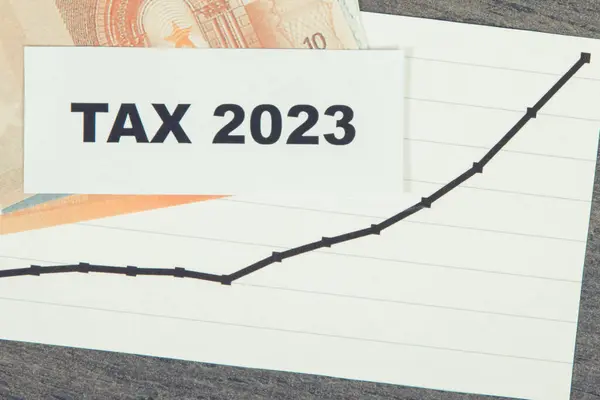 Inscription tax time, euro banknotes, rising graph showing tax increases. Calculating and paying tax. Wooden background