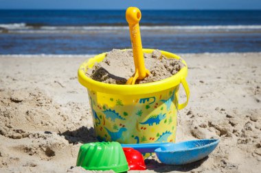 Plastik oyuncaklar plajda kumsalda rahatlamak ve oynamak için kullanılıyor. Yaz, tatil ve çocuk gelişimi