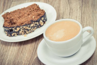 Kabaktan yapılmış taze fırınlanmış hamur işi ve bir fincan beyaz kahve. Lezzetli tatlı. Ahşap arka plan. Vintage fotoğraf