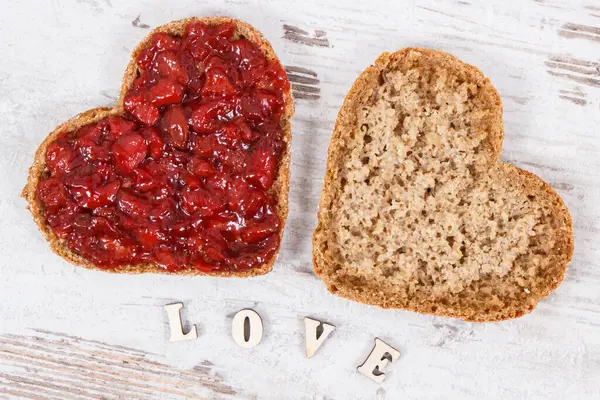 Świeżo Upieczony Chleb Pełnoziarnisty Kształcie Serca Dżemem Truskawkowym Napisem Miłość — Zdjęcie stockowe
