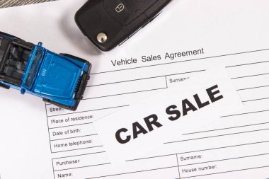 Küçük mavi oyuncak araba, siyah anahtar ve bir çeşit araç satış anlaşması. Araba satışı. Satışlar ve yeni ya da kullanılmış araba alımları