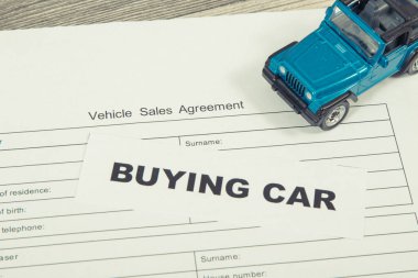 Küçük mavi oyuncak araba ve araç satış anlaşması. Araba satın alma yazıtları. Satışlar ve yeni ya da kullanılmış araba alımları