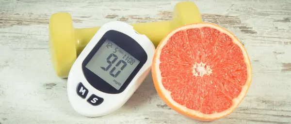 糖量计用于测量和检查糖分 新鲜成熟柚子和哑铃是否健康 糖尿病期间的健康生活方式和营养 免版税图库图片