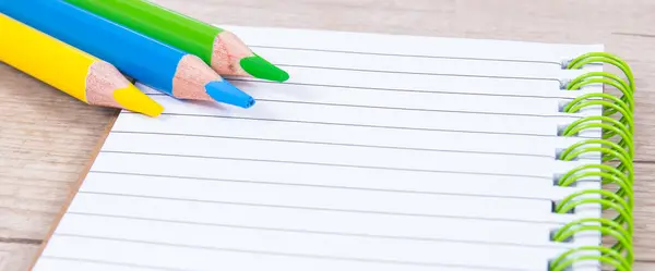 笔记和彩色蜡笔笔记本 学校或幼儿园使用的办公用品和文具配件 免版税图库照片
