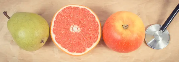 新鮮な熟した果物と古い粉砕されたペーパーの医学のステスコープ 健康的なライフスタイル 源ミネラルやビタミンとしての果物 ストック画像
