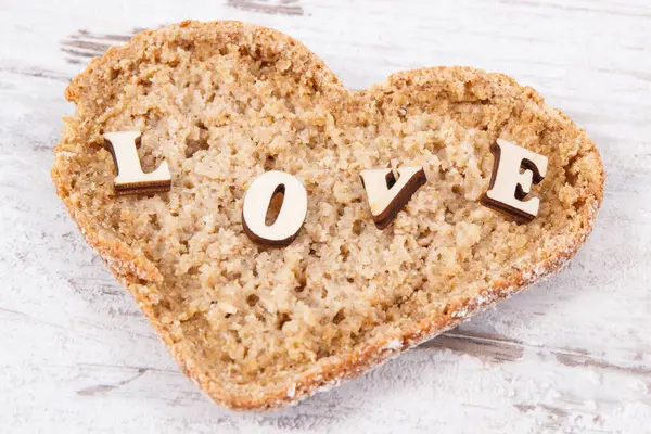 新鲜的全麦面包 心形早餐和题词爱情 古老的乡村背景 图库图片