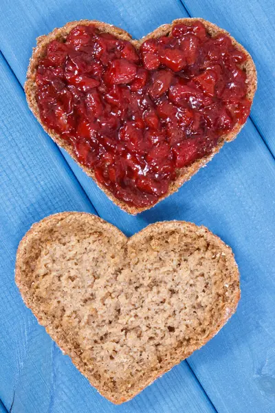 早餐用的是全麦面包和草莓果酱 心脏的形状 图库照片