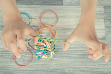 Anaokulunun elleri renkli lastik bantlarla ya da silgiyle oynuyor. Çocukların motor becerilerinin, koordinasyonun, yaratıcılığın ve mantıksal düşüncenin geliştirilmesi