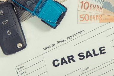 Küçük mavi oyuncak araba, siyah anahtar, euro banknotları ve araç satış anlaşması. Araba satışı. Satışlar ve yeni ya da kullanılmış araba alımları